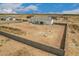An aerial shot shows a large desert lot with the home under construction and a perimeter fence at 9486 W Sandstone Mountain Dr, Casa Grande, AZ 85194