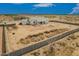 An aerial view shows a home with a large desert lot and block fence in a desert community at 9486 W Sandstone Mountain Dr, Casa Grande, AZ 85194