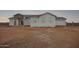 New construction home at dusk featuring brick entryway, gray roof and white exterior at 9486 W Sandstone Mountain Dr, Casa Grande, AZ 85194