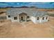 New construction home features brick entryway, gray roof, white exterior and mountain views at 9486 W Sandstone Mountain Dr, Casa Grande, AZ 85194