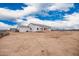 The rear exterior of a white home under a partly cloudy sky with construction materials nearby at 9486 W Sandstone Mountain Dr, Casa Grande, AZ 85194