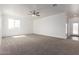 Large living room with neutral carpet, ceiling fan, and a bright, airy feel at 9486 W Sandstone Mountain Dr, Casa Grande, AZ 85194