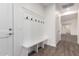 A mudroom with a wooden-look tile floor, coat rack with a bench, and a door to another room at 9486 W Sandstone Mountain Dr, Casa Grande, AZ 85194