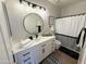 Modern bathroom with white vanity, round mirror, and stylish black and white accents at 9827 N Desert Rose Dr, Fountain Hills, AZ 85268