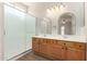 Bathroom featuring a double vanity, two mirrors, and a glass-enclosed shower at 12238 W Monroe St, Avondale, AZ 85323