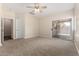 Spacious bedroom with neutral carpet, ample natural light, and a ceiling fan at 12238 W Monroe St, Avondale, AZ 85323