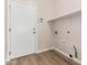 Functional laundry room with laminate floors, shelf, and hookups at 12238 W Monroe St, Avondale, AZ 85323