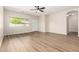 Bright living room with wood flooring, a fan, and ample natural light streaming in through a large window at 12238 W Monroe St, Avondale, AZ 85323