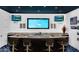A stylish bar featuring a pool view window, dual TVs, and ample seating for entertaining guests at 13209 N 17Th Pl, Phoenix, AZ 85022