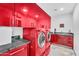 Contemporary laundry room with red cabinets, granite countertops, and modern appliances at 13209 N 17Th Pl, Phoenix, AZ 85022