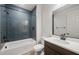 Bathroom with blue subway tile, tub, and white vanity, complemented by dark fixtures at 13503 W Calle De Baca --, Peoria, AZ 85383