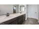 Bathroom vanity with dual sinks, dark cabinetry, and a large mirror at 13503 W Calle De Baca --, Peoria, AZ 85383