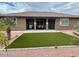 Inviting backyard featuring a covered patio, artificial lawn, and well-maintained desert landscaping at 18306 W Beck Ln, Surprise, AZ 85388