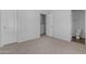 Bedroom with neutral carpet featuring a bathroom, closet, and a doorway leading to another space at 2402 E 5Th St # 1621, Tempe, AZ 85288