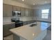 Well-lit kitchen featuring quartz countertops, stainless steel appliances, and ample cabinet space at 25151 W Wayland Dr, Buckeye, AZ 85326