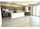 Modern open kitchen boasts gray cabinets, stainless steel appliances, large island, and tile flooring throughout the living space at 25151 W Wayland Dr, Buckeye, AZ 85326