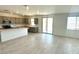 A modern kitchen boasts gray cabinets, stainless steel appliances, and a large island, adjacent to a brightly lit living area at 25151 W Wayland Dr, Buckeye, AZ 85326