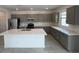 Modern kitchen with stainless steel appliances, gray cabinetry, and a large white center island at 25151 W Wayland Dr, Buckeye, AZ 85326