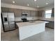 Modern kitchen with stainless steel appliances, gray cabinetry, and a large white center island at 25151 W Wayland Dr, Buckeye, AZ 85326