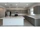 Modern kitchen featuring gray cabinets, quartz countertops, and stainless steel appliances at 25151 W Wayland Dr, Buckeye, AZ 85326