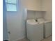 Functional laundry room featuring a washer, dryer, and storage shelf at 25151 W Wayland Dr, Buckeye, AZ 85326