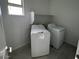 Bright laundry room with modern washer and dryer and convenient shelving at 25151 W Wayland Dr, Buckeye, AZ 85326