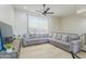 Spacious living room featuring an oversized gray couch and a ceiling fan at 4530 W Paradise Dr, Glendale, AZ 85304