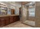 Bathroom with glass-enclosed tile shower, dual sink vanity, and ample lighting at 5008 E Nisbet Rd, Scottsdale, AZ 85254