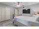 Comfortable bedroom with white trim, gray walls, wood-look floors, ceiling fan, and wall mounted TV at 5008 E Nisbet Rd, Scottsdale, AZ 85254