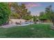 Wide angle view of the expansive backyard features a large pool, fire pit, waterfall and mature landscaping at 5008 E Nisbet Rd, Scottsdale, AZ 85254