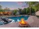 Beautiful swimming pool with rock waterfall, a fire pit and a lush tropical surrounding landscape at 5008 E Nisbet Rd, Scottsdale, AZ 85254