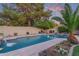Large backyard pool with waterfall feature, fire pit, lush landscaping and mature trees at 5008 E Nisbet Rd, Scottsdale, AZ 85254