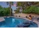Tranquil backyard oasis with pool, fire pit, comfortable seating, and serene landscaping at 5008 E Nisbet Rd, Scottsdale, AZ 85254