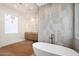 Bright bathroom featuring a soaking tub, marble tile shower, and oak vanity with sconces at 6202 E Larkspur Dr, Scottsdale, AZ 85254