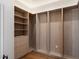 Spacious walk-in closet with built-in wood shelving, drawers, and hardwood floors at 6202 E Larkspur Dr, Scottsdale, AZ 85254