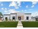 Striking modern home features white brick accents, clean lines, and lush green lawn at 6202 E Larkspur Dr, Scottsdale, AZ 85254