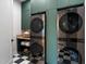 Modern laundry room features sleek, stacked washer and dryer units and stylish checkered floors at 6202 E Larkspur Dr, Scottsdale, AZ 85254