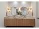 Close-up of bathroom double vanity with modern light fixtures, mirrors, and light wood cabinets at 6202 E Larkspur Dr, Scottsdale, AZ 85254