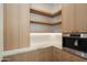 Walk-in pantry with custom shelving, wood cabinets, and modern appliances at 6202 E Larkspur Dr, Scottsdale, AZ 85254