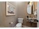 Elegant powder room featuring a marble sink, designer mirror, and contemporary fixtures at 6202 E Larkspur Dr, Scottsdale, AZ 85254