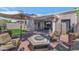 Open backyard patio with multiple seating areas, fire pit, desert landscaping, and shaded seating arrangement at 7917 E Cactus Wren Rd, Scottsdale, AZ 85250