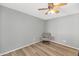 Simple bedroom with ceiling fan, wood-look floors, and single chair to compliment the light gray walls at 7917 E Cactus Wren Rd, Scottsdale, AZ 85250