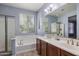 Bathroom featuring a double sink vanity, soaking tub and walk-in shower at 865 E Rojo Ct, Gilbert, AZ 85297