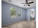 Neutral toned bedroom featuring tile flooring, a ceiling fan, and natural light from two windows at 865 E Rojo Ct, Gilbert, AZ 85297