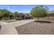 Well-maintained single-Gathering home with desert landscaping, lush tree, and an inviting driveway at 865 E Rojo Ct, Gilbert, AZ 85297