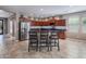 Spacious kitchen featuring granite countertops, stainless steel appliances, tile flooring, and three barstool seats at 865 E Rojo Ct, Gilbert, AZ 85297