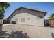 A view of the back exterior shows small windows, a low-maintenance landscape, and an AC unit at 1001 N Quail Ln, Gilbert, AZ 85233