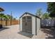 A backyard view showcases a shed with a dark gray door and a low-maintenance yard at 1001 N Quail Ln, Gilbert, AZ 85233