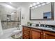 A neutral bathroom with custom tile work and a granite countertop creates a spa like experience at 1001 N Quail Ln, Gilbert, AZ 85233