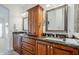Bathroom offers double sinks, ample dark wood storage, granite countertops, and custom mirrors at 1001 N Quail Ln, Gilbert, AZ 85233
